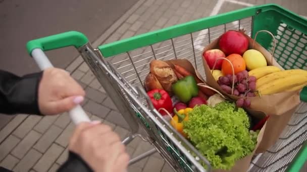 Potraviny ze supermarketu ve venkovním vozíku. Dodávka jídla během karantény. Cruft papírové eko tašky na nákupy. Čerstvé ovoce a zelenina, vegan - Záběry, video