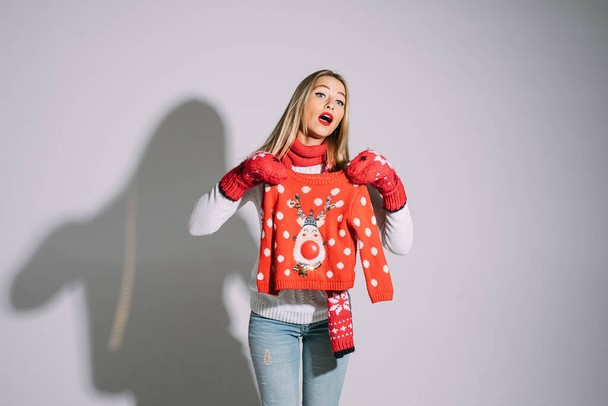 Confused blonde lady posing with Christmas sweater - Photo, Image