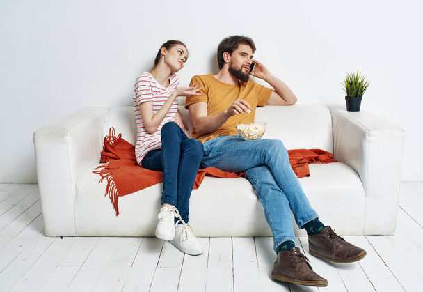 Mujer bonita y hombre barbudo viendo televisión en el sofá en el interior - Foto, Imagen