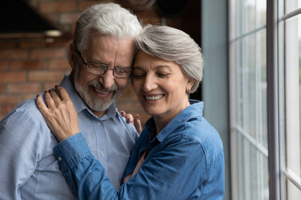 Close up happy mature couple hugging with closed eyes - Photo, Image