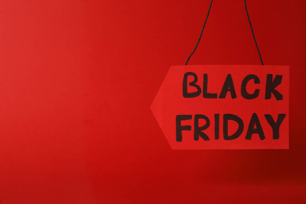 Tag with phrase Black Friday on red background. Space for text - Foto, Imagem