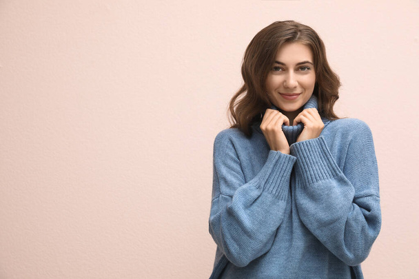 Beautiful young woman wearing warm blue sweater on light pink background. Space for text - Fotografie, Obrázek