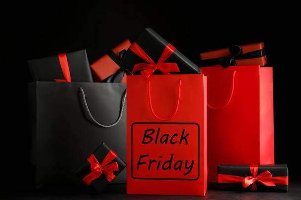 Paper shopping bags and gift boxes on dark background. Black Friday sale - Foto, Imagem