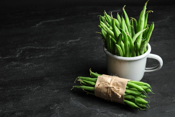 Delicious fresh green beans on black table, space for text - Foto, afbeelding