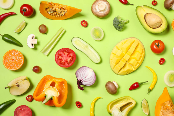 Flat lay composition with fresh organic fruits and vegetables on light green background - Foto, imagen