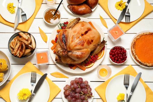 Traditional Thanksgiving day feast with delicious cooked turkey and other seasonal dishes served on white wooden table, flat lay - Foto, Bild