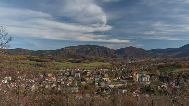 Punto de vista Poustevnikuv kamen sobre la ciudad de Hejnice en las montañas de Jizerske en el soleado día de otoño - Foto, Imagen