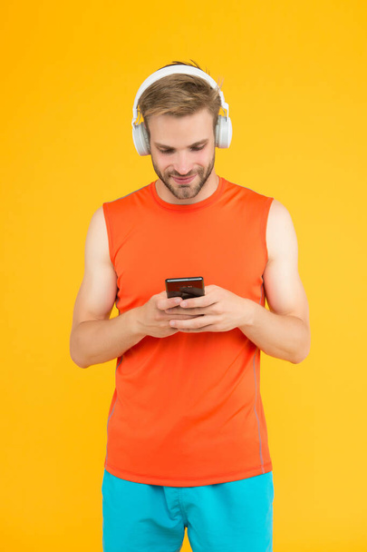 cheerful bearded man listen music in digital earphones using mobile phone app wearing sporty clothes for workout, social network - Fotoğraf, Görsel