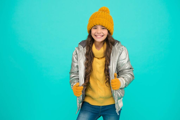 happy child feel comfortable and warm in padded jacket and knitted clothing in winter weather, cold season - Фото, изображение