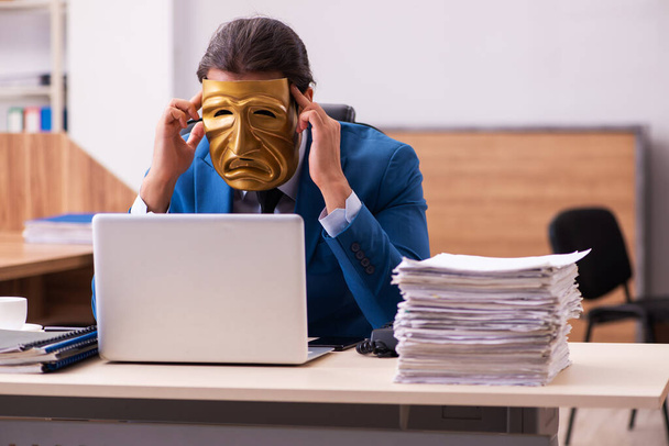 若いです男性従業員を着て悲しいマスクでオフィス - 写真・画像