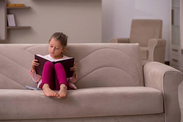 Small girl reading book at home - Photo, Image