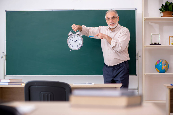 Vecchio insegnante maschio nel concetto di gestione del tempo - Foto, immagini