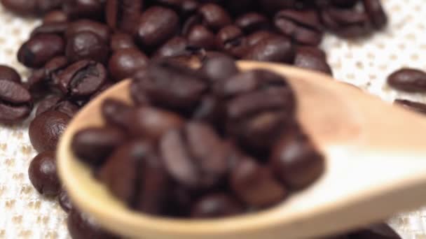 kávová zrna zblízka nalije dřevěnou lžíci. selektivní zaměření - Záběry, video