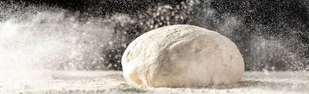 yeast dough for bread or pizza on a floured surface, with flour splash. Cooking bread. Kneading the Dough. Long banner format - Photo, Image