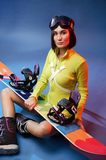 かわいいです女の子で黄色スポーツウェアでスノーボードとアイウェア - 写真・画像