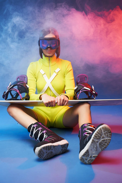 Atmpospheric photography of sportswoman with snowboard - Fotó, kép