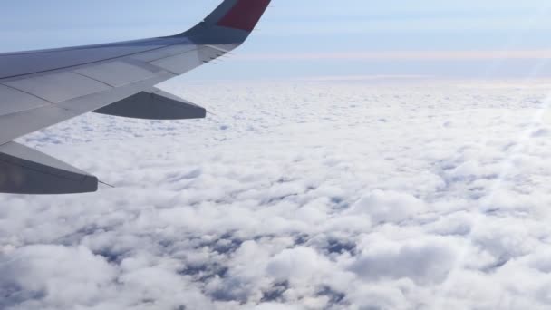 Bulutların üzerinde uçan bir uçağın kanadı. Seyahat kavramı - Video, Çekim