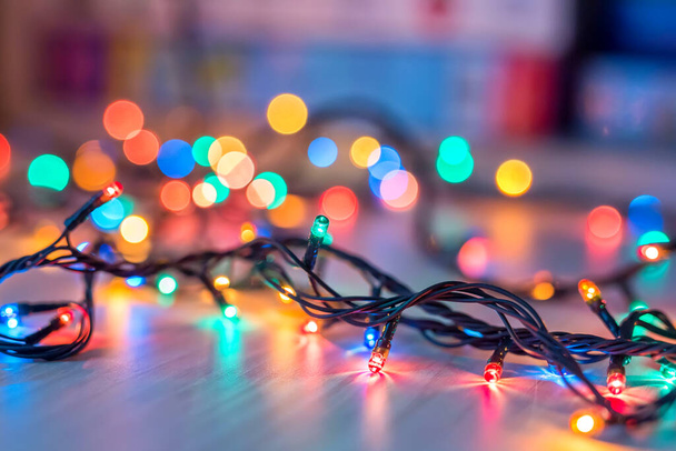Christmas lights on dark blue background with copy space. Decorative garland - 写真・画像