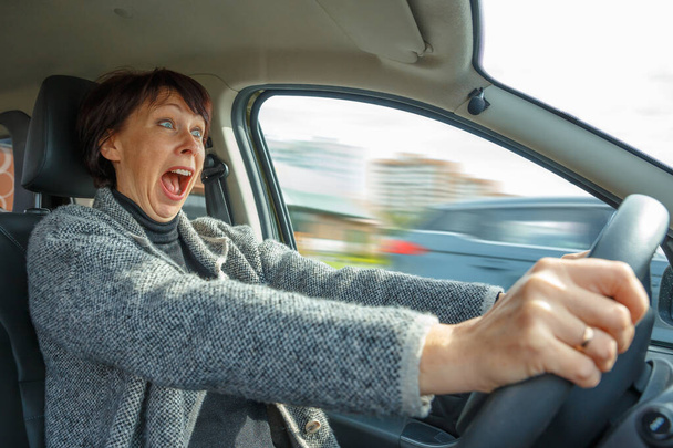 Portrait of a woman driving a car. Stress when learning to drive - Valokuva, kuva
