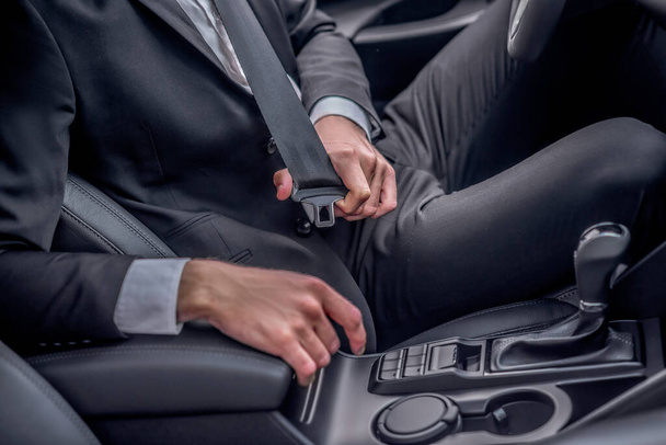 Close-up of drivers hands fastening seat belt - Фото, зображення