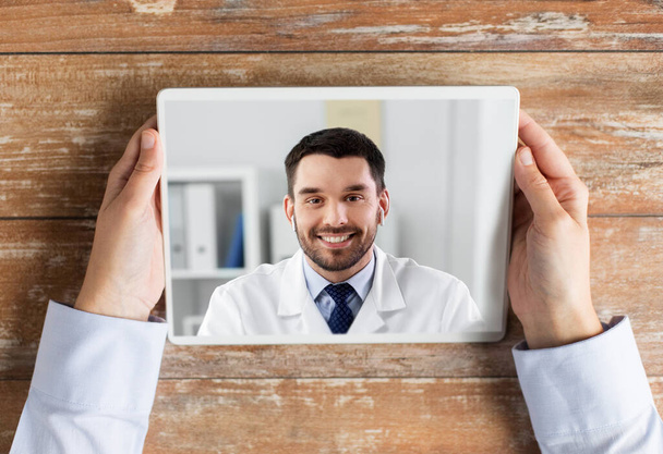 hands of holding tablet pc with doctor on screen - Photo, Image