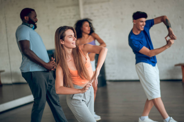 ダンス教室で新しい動きを学ぶ人々のグループ - 写真・画像