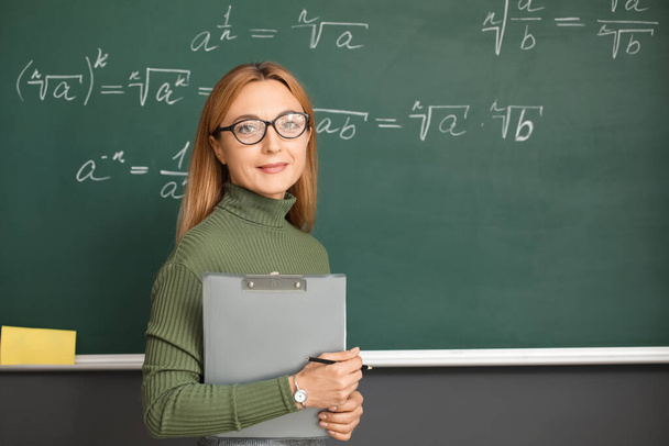 Érett matematika tanár közelében táblán az osztályteremben - Fotó, kép