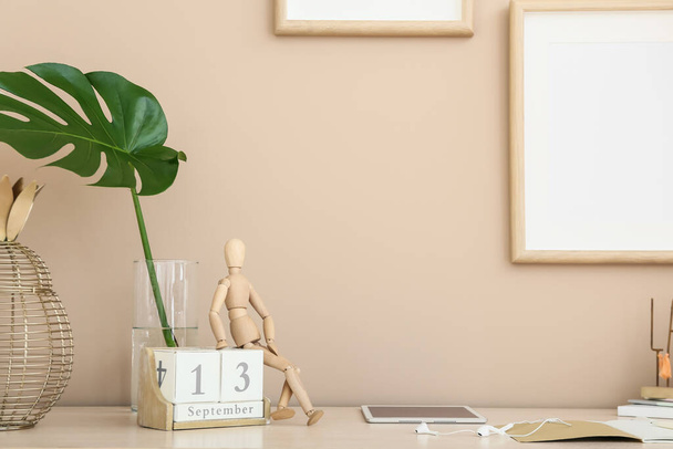 Dřevěná figurína s kalendářem na stole v pokoji - Fotografie, Obrázek