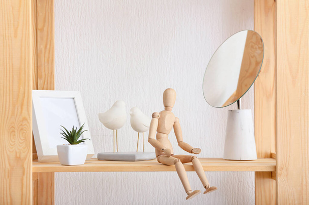 Wooden mannequin on shelf in room - 写真・画像