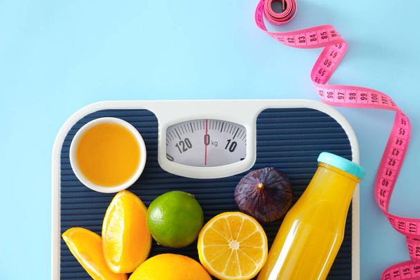 Свежие продукты, весы и измерительная лента на цветном фоне. Концепция питания - Фото, изображение