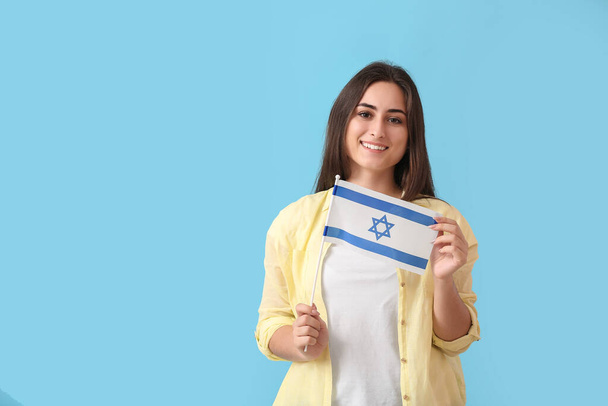 Young woman with the flag of Israel on color background - Photo, Image