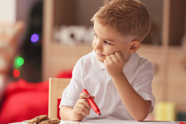 Cute little boy writing letter to Santa at home on Christmas eve - Photo, Image