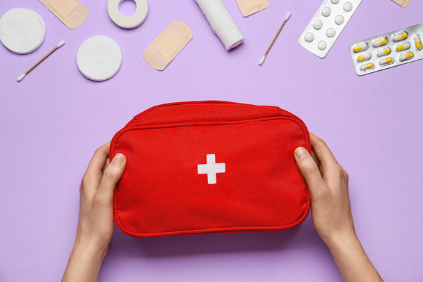 Hands with first aid kit on color background - Foto, Bild