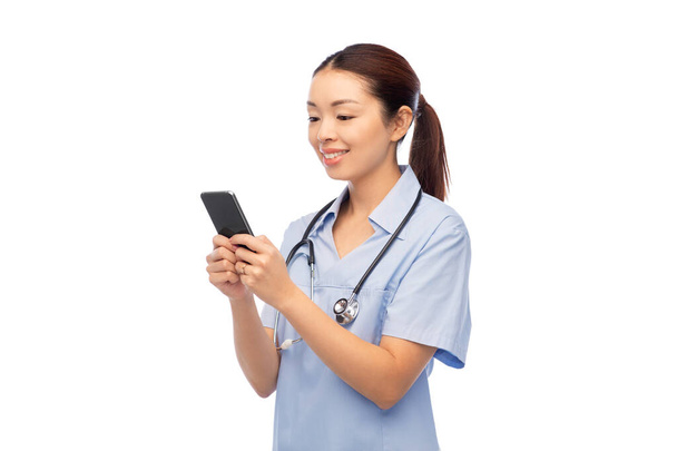 happy asian female doctor or nurse with smartphone - 写真・画像