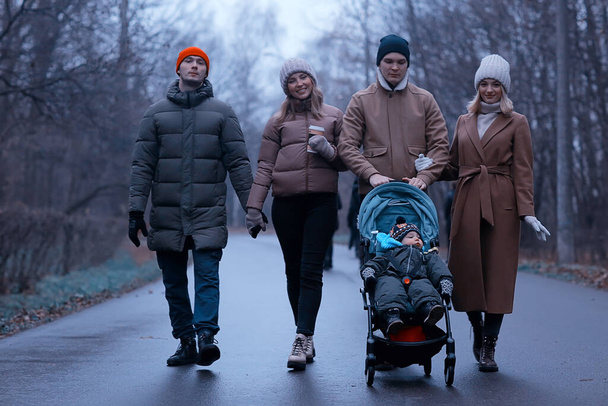 group friends adults park gloomy autumn, young parents walk landscape november in the city - Foto, imagen