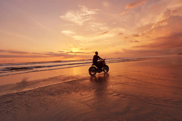 Man And Motorcycle On Ocean Beach At Beautiful Tropical Sunset. Biker Silhouette On Motorbike On Sandy Coast Near Sea In Bali, Indonesia. - Фото, зображення
