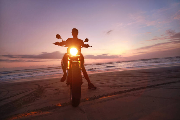 Man On Motorcycle Portrait On Ocean Beach At Beautiful Tropical Sunset. Front View Of Handsome Biker On Motorbike On Sandy Coast In Bali, Indonesia. - Foto, Bild
