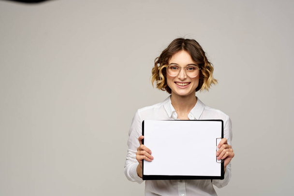 Business woman in a light shirt and a folder with documents in hands cropped view of work - Foto, Imagen