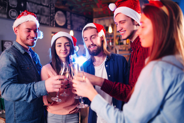 Group of happy friends celebrating  new year's party.  A crowd of young  people with sparklers, gifts and clinking glass. Party, holidays,  nightlife, holidays. Christmas. - Φωτογραφία, εικόνα