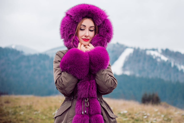 Mooie vrouw in modieuze kleurrijke parkjas in koude tijd buiten, Fashion for lady, bontjas, herfst - winterseizoen met goed humeur en luxe kleding, lichte make-up - Foto, afbeelding