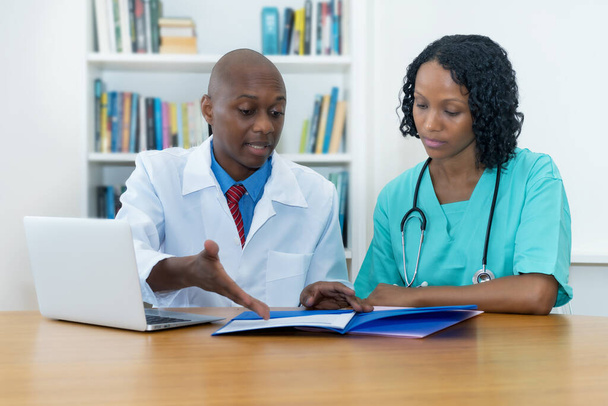 Afro-Amerikan tıp ekibi hastanedeki hasta teşhisi hakkında konuşuyor. - Fotoğraf, Görsel