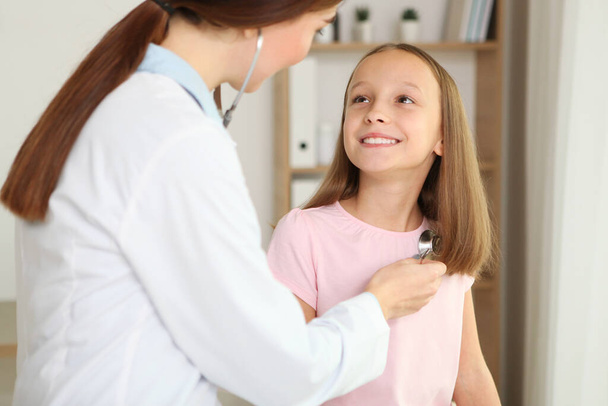 Jeune fille médecin pédiatre fait un check-up à une petite fille - Photo, image