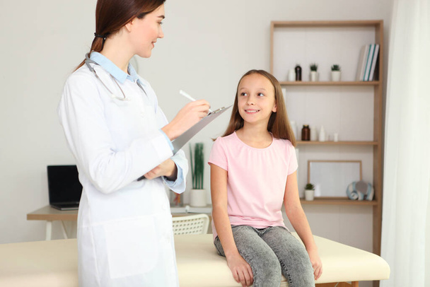 Young girl doctor pediatrician makes a checkup to a little girl - Fotó, kép