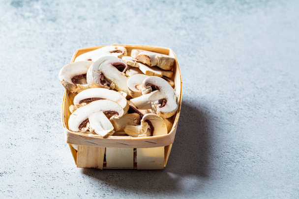 Raw chopped champignons in a wicker basket. Vegan ingredient concept. - Foto, Bild
