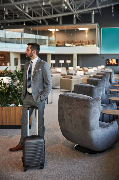 Traveler standing with his luggage at the waiting room - Foto, Bild