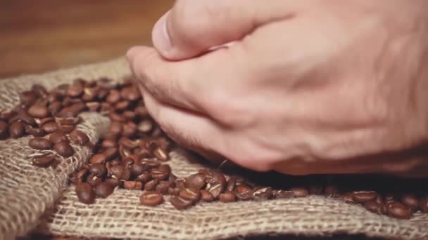 αργή κίνηση του αρσενικού χεριού αρπάζοντας καβουρδισμένους κόκκους καφέ - Πλάνα, βίντεο
