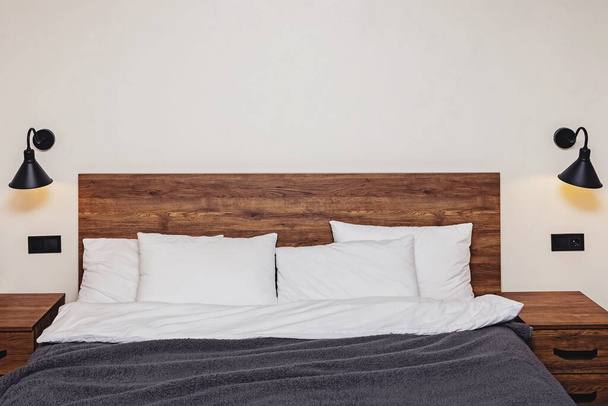 Modern bedroom interior. Bed with wooden headboard - Foto, Imagem