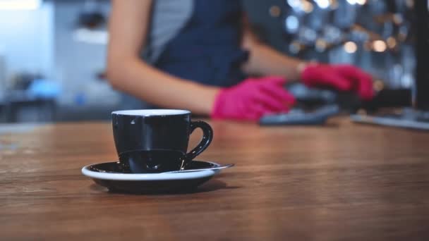 csésze kávé a fa pult homályos barista a háttérben - Felvétel, videó