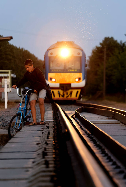 Menino ciclista perigoso na ferrovia em frente ao trem 2020 - Foto, Imagem