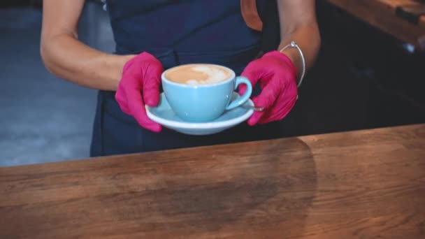 przycięty widok barista obsługujących cappuccino na drewnianym stole - Materiał filmowy, wideo